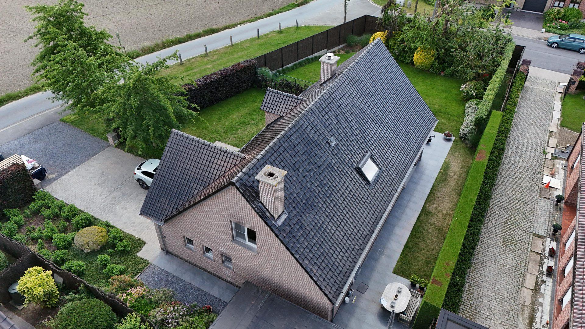 Dakwerken in Izegem: vrijstaande villa met nieuwe antraciet dakpannen en Velux door Recotex