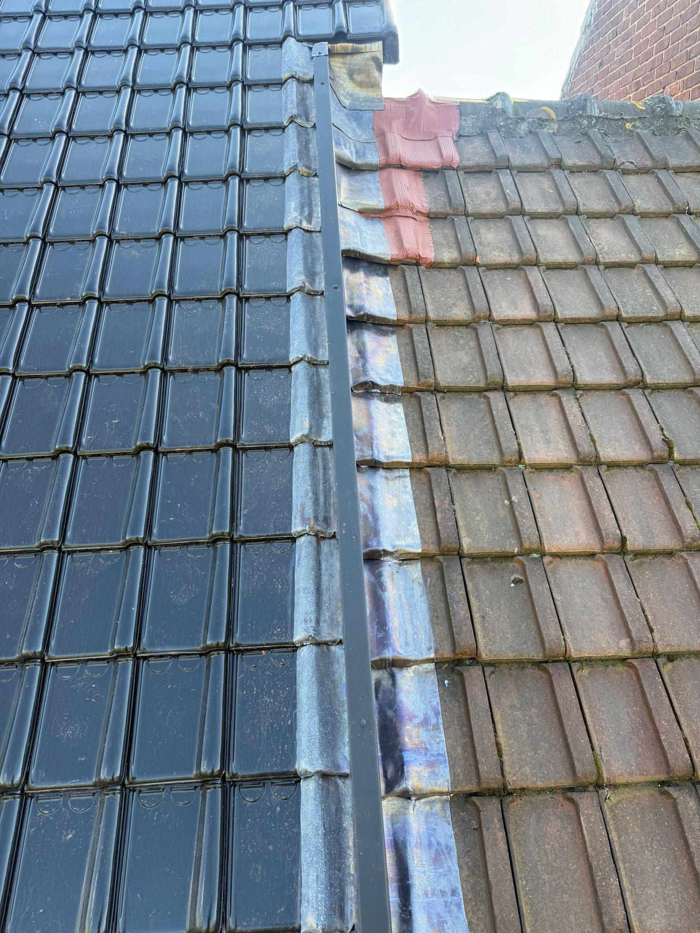 Contrast tussen het nieuwe zwarte dak en het oude buurdak in Melle