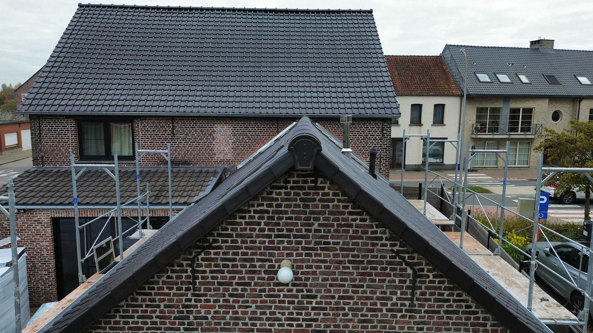 Detail van de zwarte windveer en dakoversteek aan de puntgevel in Putte