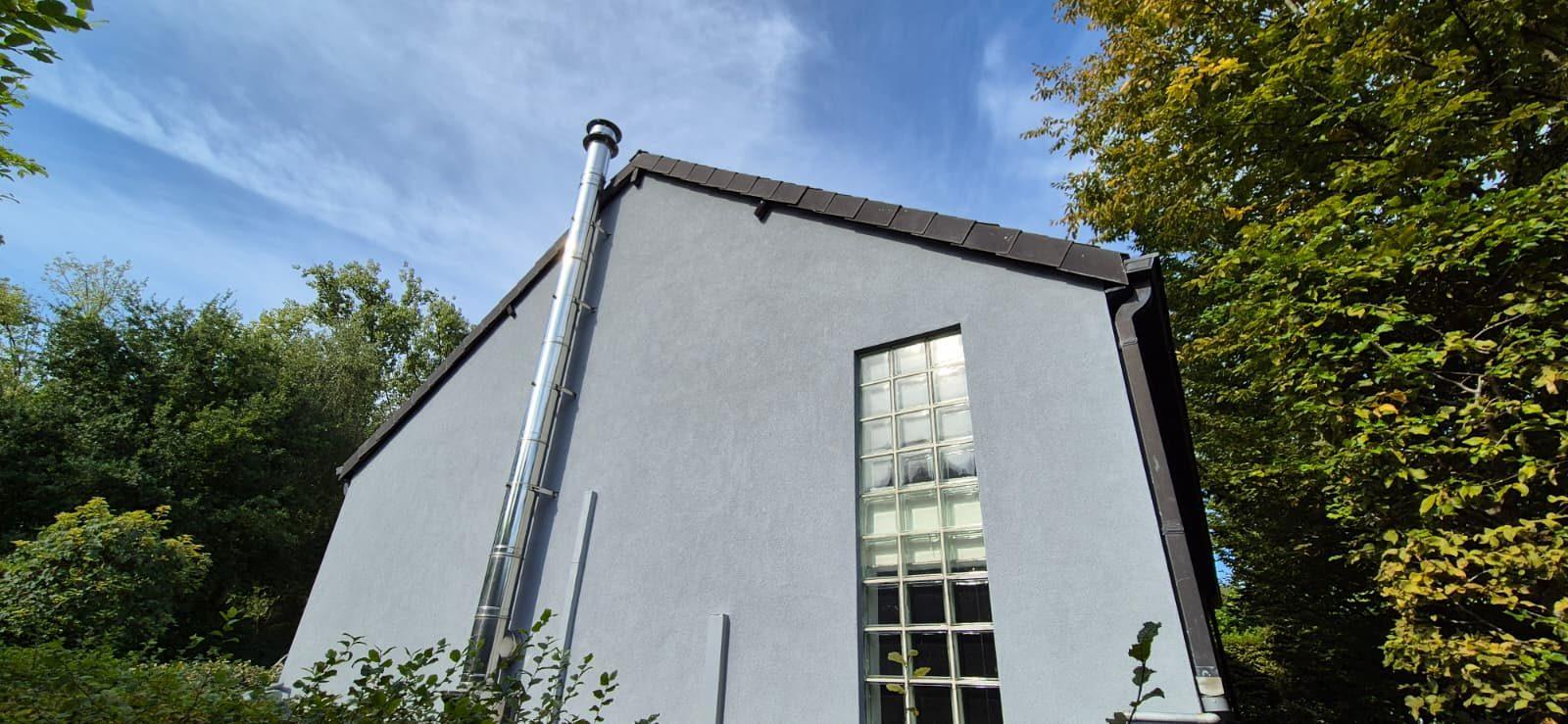 Puntgevel met glasbouwsteenraam en lichtgrijze crepi in Bonheiden